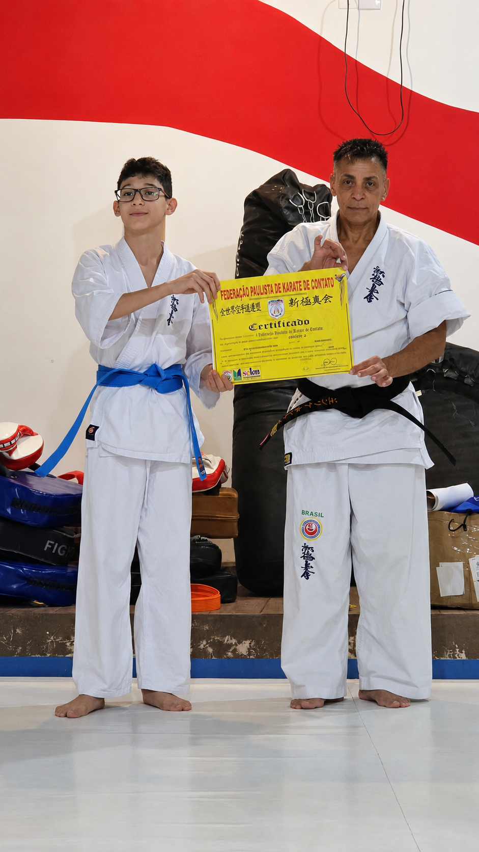 Aluno recebendo certificado ao lado do Shihan Henrique